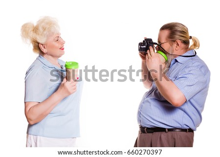 Grandfather With a long beard making photo of grandmother with coffee on white background