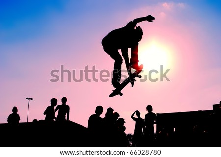 Jumping skateboarder silhouette over scenic sunset sky background