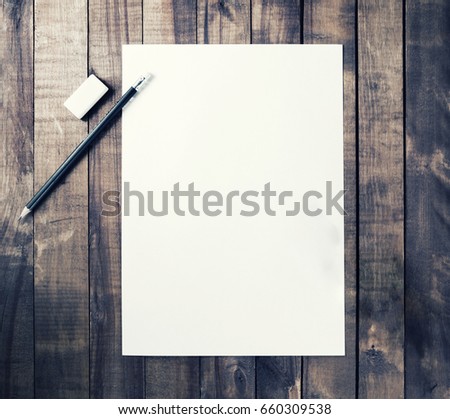 Photo of blank stationery: letterhead, pencil and eraser on vintage wooden table background. Responsive design mockup for placing your design. Top view.