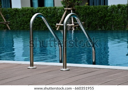 Aluminum pool stairs on the brown side of pool Royalty-Free Stock Photo #660351955