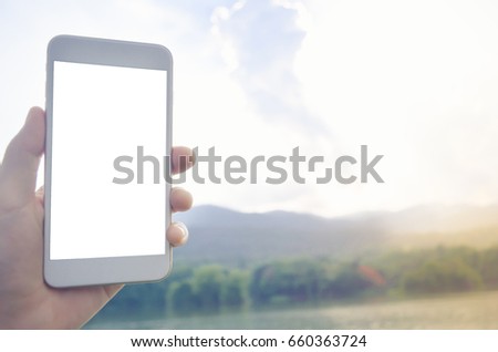 Image of smart phone with blank white screen in gold color. Background of cloudy sky. Technology. yellow flare.