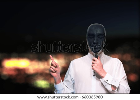 A young man in a black mask against a background of a blurry night city. Place for your text or image