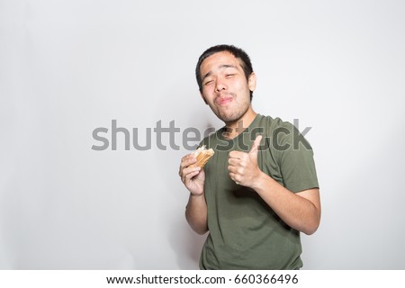 unhealthy eating concept, man enjoy and happy to eat his junk food with delicious face expression Royalty-Free Stock Photo #660366496