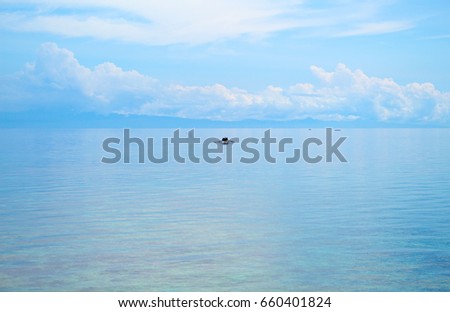 Seascape with fisherman boat and blue sky. Relaxing sea view with still seawater. Seaside vacation day. Blue sky and water reflection. White cloud on blue sky. Tropic seashore. Holiday banner