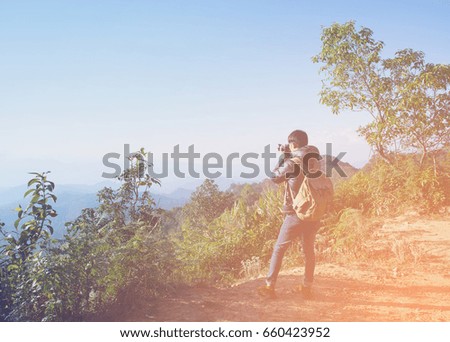 Young professional traveler man with camera shooting outdoor, fantastic mountain landscape