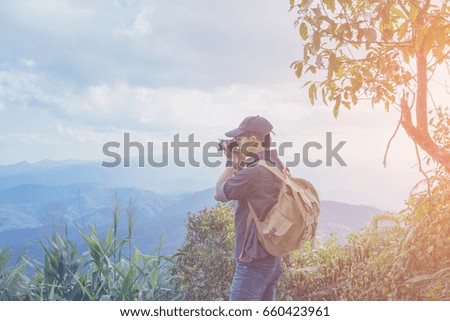 Young professional traveler man with camera shooting outdoor, fantastic mountain landscape