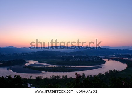 Landscape of the meandering river and gradation of the sky at dawn, river surface reflecting the sky, River Shinano, Ojiya City, Niigata, Japan