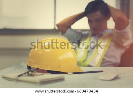 Engineer stress holding his head with hands sitting at the table in the office Royalty-Free Stock Photo #660470434