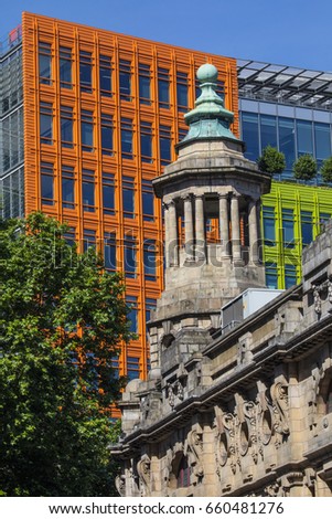 The tower of the famous Shaftesbury Theatre with the bright coloured facade of Central Saint Giles in the background in central London.