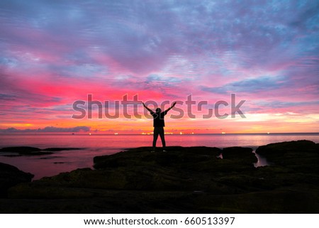 Silhouette man on the rock with Beautiful background Twilight time, Seascape.  