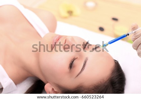 Woman gets injection in her face. Beauty woman giving injections. Young woman gets beauty facial injections in the cosmetology salon. Face aging injection. Aesthetic Medicine, Cosmetology