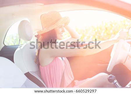 Side view of happy woman driving car