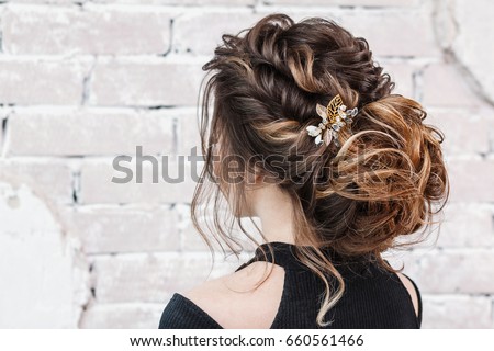 attractive young brunette woman with beautiful hairstyle with hair detail accessory, closeup rear view Royalty-Free Stock Photo #660561466