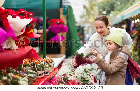 Family of two  choosing mistletoe decorations for Xmas