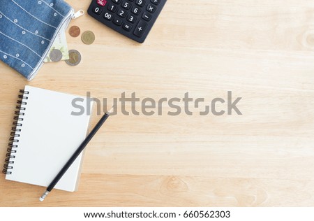 money from wallet, black calculator and notebook paper with pencil on wood table, copy space