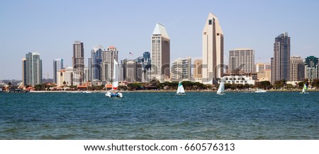 Prominent architecture stands at the waterfront in San Diego as sailboats sail the bay