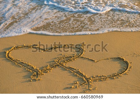 Two hearts together. Heart on a wet sand. Painted heart. Season of travel. Summer trips to the sea. Concept of leisure and travel. Waves wash away the painted heart on the sand
 Royalty-Free Stock Photo #660580969