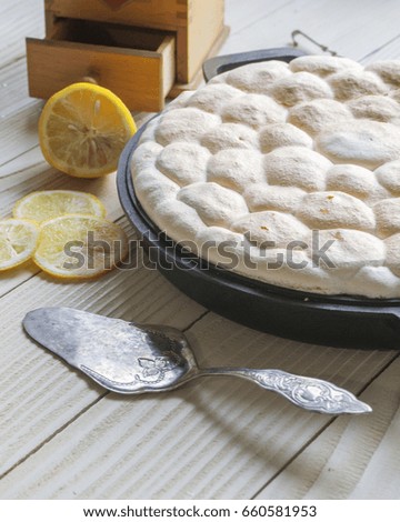 Homemade Lemon Meringue pie on white wooden table.