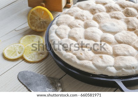 Homemade Lemon Meringue pie on white wooden table.