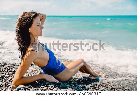 Perfect young woman relaxed on beach in Hawaii and tropical ocean, wearing stylish bikini