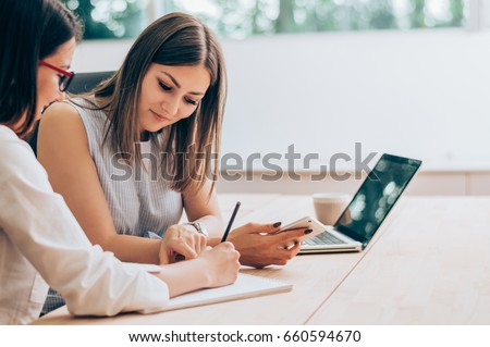 Two female colleagues in office working together. Royalty-Free Stock Photo #660594670