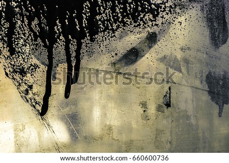 Black, grey spilled paint on transparent, dirty glass surface. Stains, splashes of oil paint. Abstraction