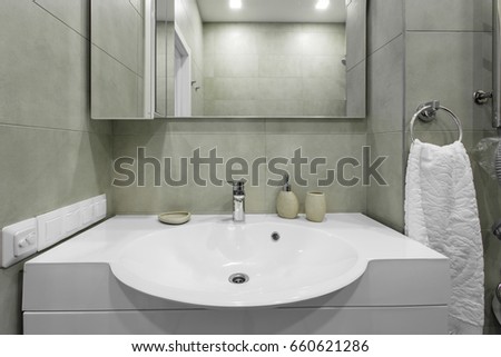Mixer, sink and mirror in a modern bathroom, interior