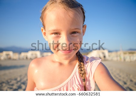 Little girl making video or photo of tropical beach with her camera for the memory