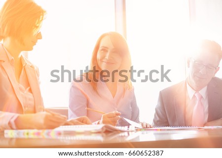 Smiling businesswoman with colleagues in meeting room