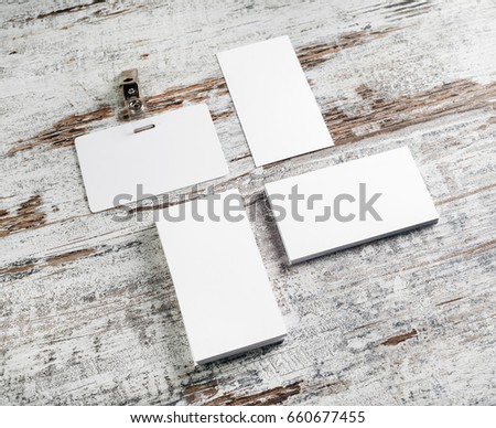 Business cards and badge on vintage wooden table background. Photo of blank stationery. Responsive design mockup with plenty of copy space.