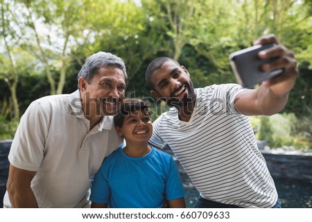 Happy multi-generation family taking selfie together at park