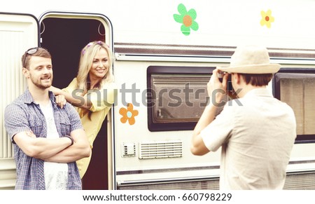 Happy friends taking pictures of each other outdoors at summer. Trip, holiday, vacation, journey concept.