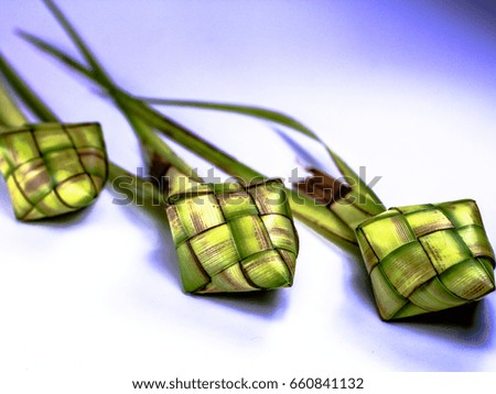Asian cuisine ketupat or packed rice in low light setting on blue background.