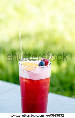 Red summer cocktail with berries and lemon