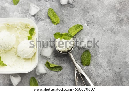 Mint ice cream in spoon on a gray background. Top view, copy space. Food background