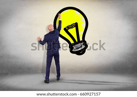 View of a Businessman in front of a wall with Innovation bulb lamp turned on -Inspiration concept