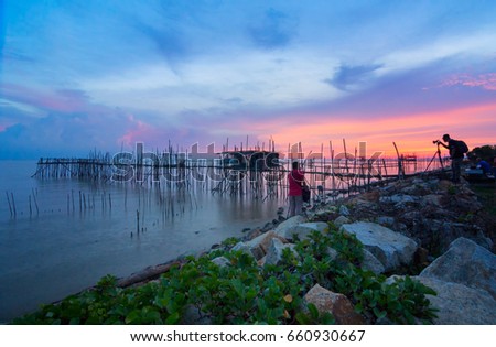 The view of burning sunset with old jetty at beach. Parit Jabar Batu Pahat Johor. This image may contain noise ,blurry clouds due to long exposure, soft focus and poor lighting