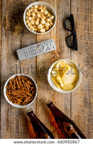 home party with TV watching, snacks and beer on wooden background top view