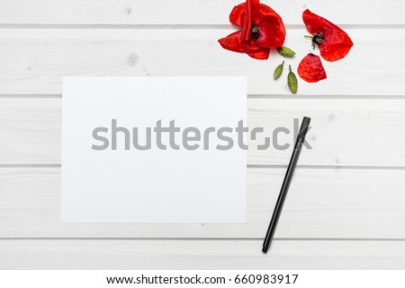 White ship deck tabletop scene with poppies and a blank white paper