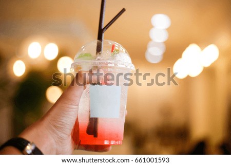 a glass of pink soda on man hand with background bokeh