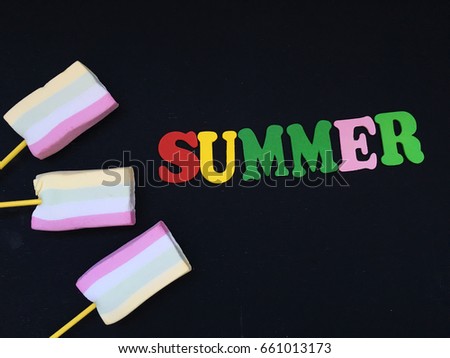 summer wooden letters on black background with marshmallow ice cream. concept summer 