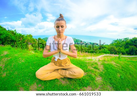 Yoga. The woman practices yoga at dawn, there is an asana on a stone, dawn and an image of the girl, to enjoy dawn, to be happy with life, a beautiful body, ideal yoga,The girl meditates