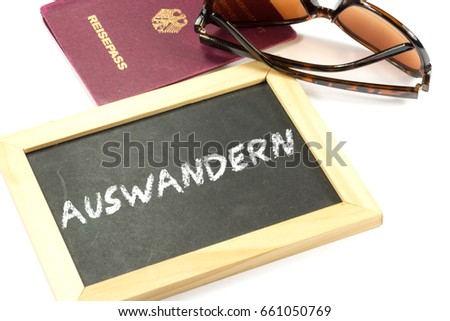 A German passport, sunglasses and a chalkboard with the German word for emigration