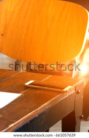 Mobile phone on wood table in coffee shop or restaurant