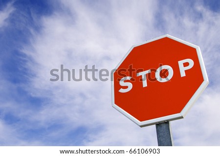 forefront of a stop sign with a cloudy sky
