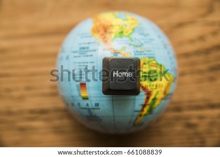 word home on button of keyboard. globe map lie on wooden table. Home word with keyboard buttons