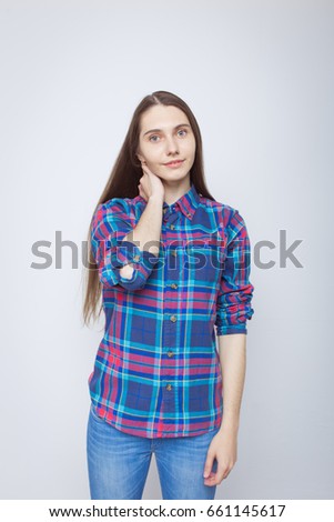 beautiful young girl with long hair clinging to his neck. dressed in jeans and a colored shirt. emotional woman. posing in a photo Studio. the desktop Wallpaper and decals