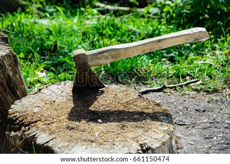 Axe in wood stump Royalty-Free Stock Photo #661150474