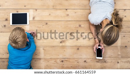 kids playing with mobile phone and tablet pc Royalty-Free Stock Photo #661164559