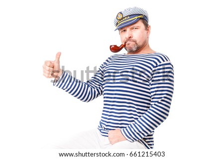 A man sailor in a cap with a smoking pipe in front of a white background